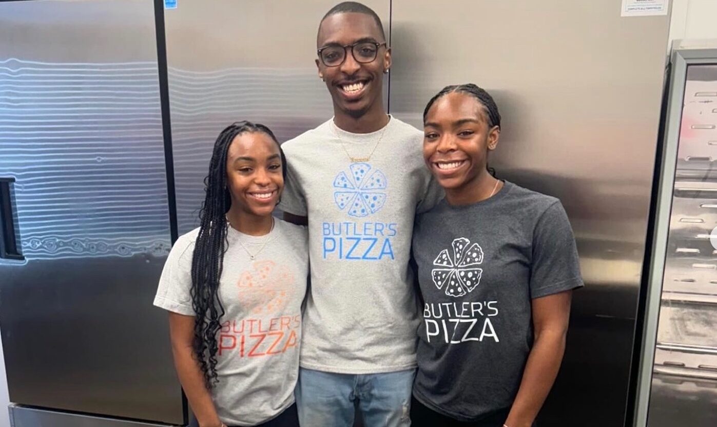 This photo shows Dionne Butler's twin daughters, Dejanae and Dominae, with their brother, Daion, standing between them, all wearing t-shirts and smiling happily in the restaurant's kitchen.