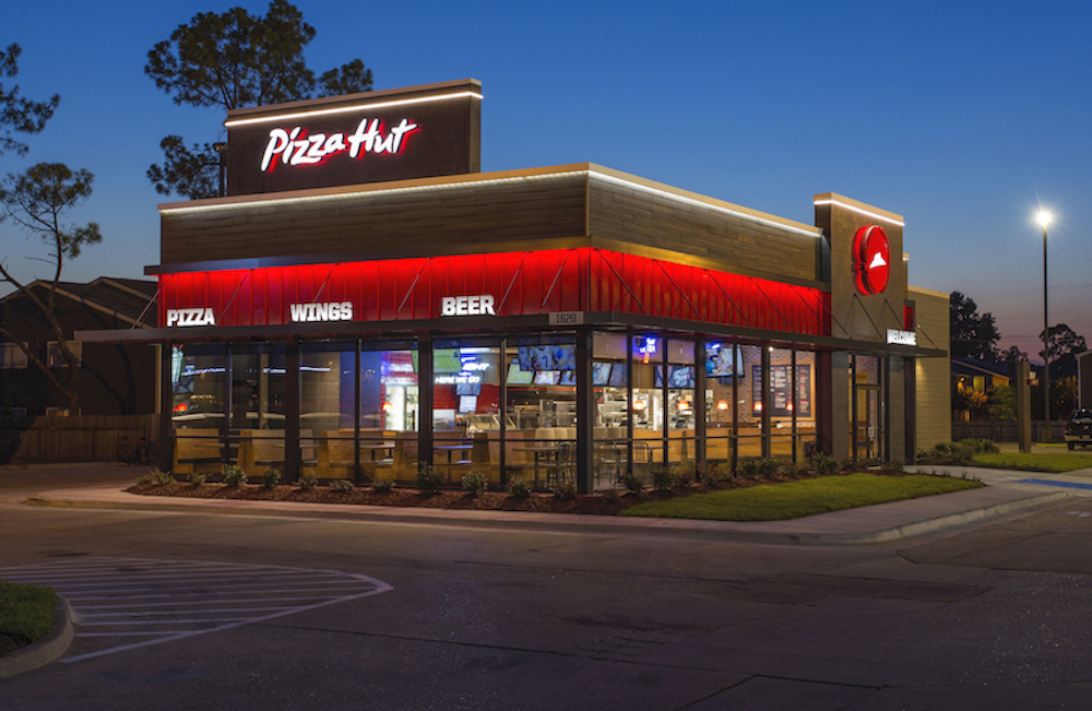 This photo shows the exterior of a Pizza Hut restaurant against a dark blue background.
