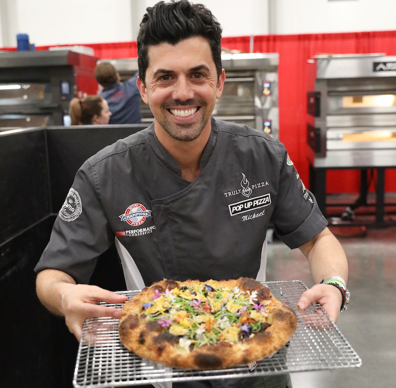 This photo shows Michael Vakneen holding up his award-winning pizza.