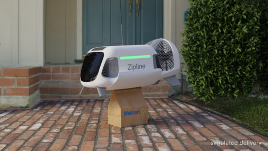 This photo shows a P2 drone sitting outside a customer's house with a package attached at the bottom of the drone.