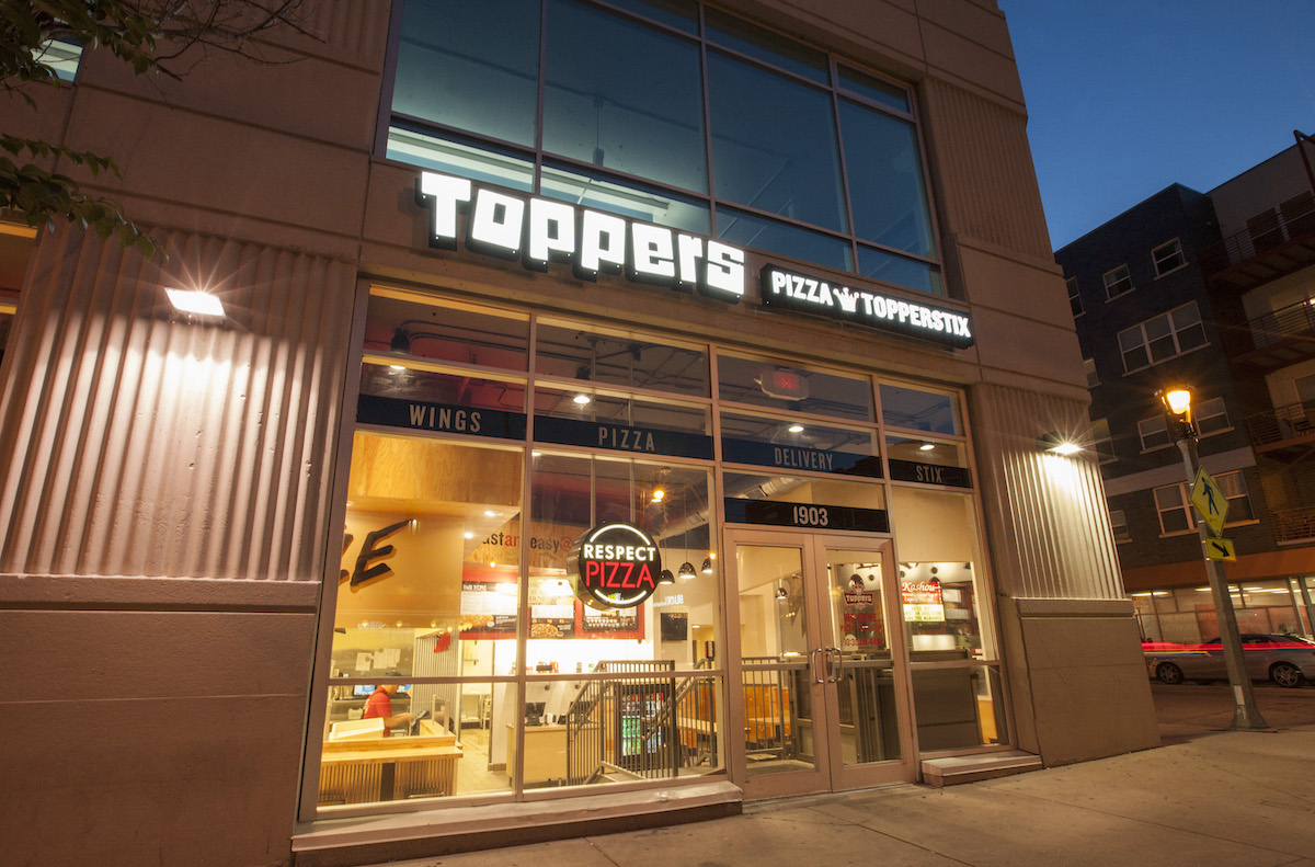 A Toppers Pizza storefront at dusk.