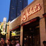 The exterior of a Lou Malnati's storefront shown at dusk.