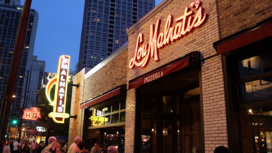 The exterior of a Lou Malnati's storefront shown at dusk.