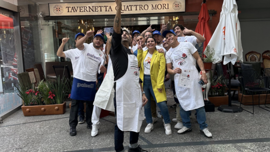 A group of about 15 pizza makers pose for a selfie on the streets of Mexico City.