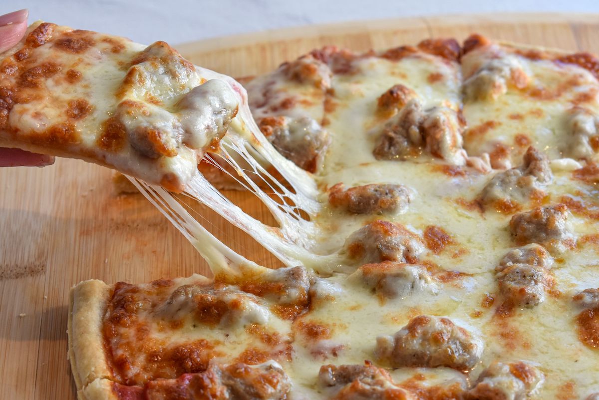 A cheese pull of a beer pizza from Home Run Inn.