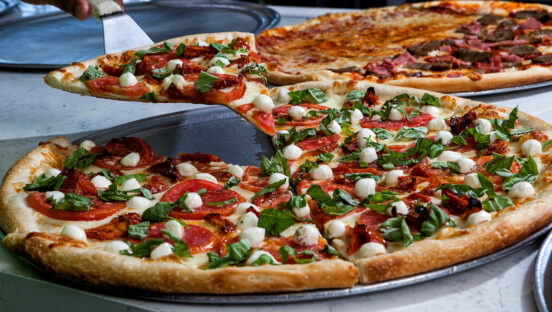 This photo shows a couple of different pizzas from Cannoli Pizza Kitchen.