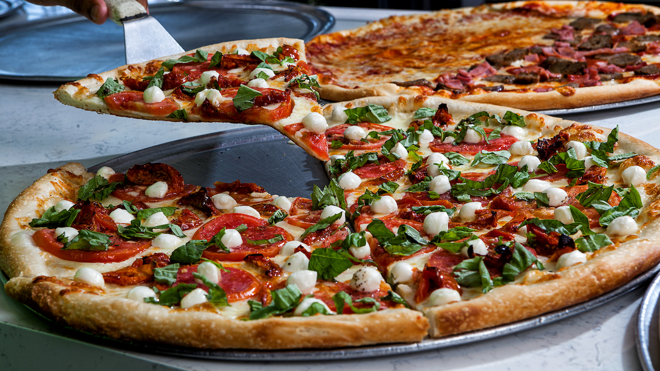This photo shows a couple of different pizzas from Cannoli Pizza Kitchen.