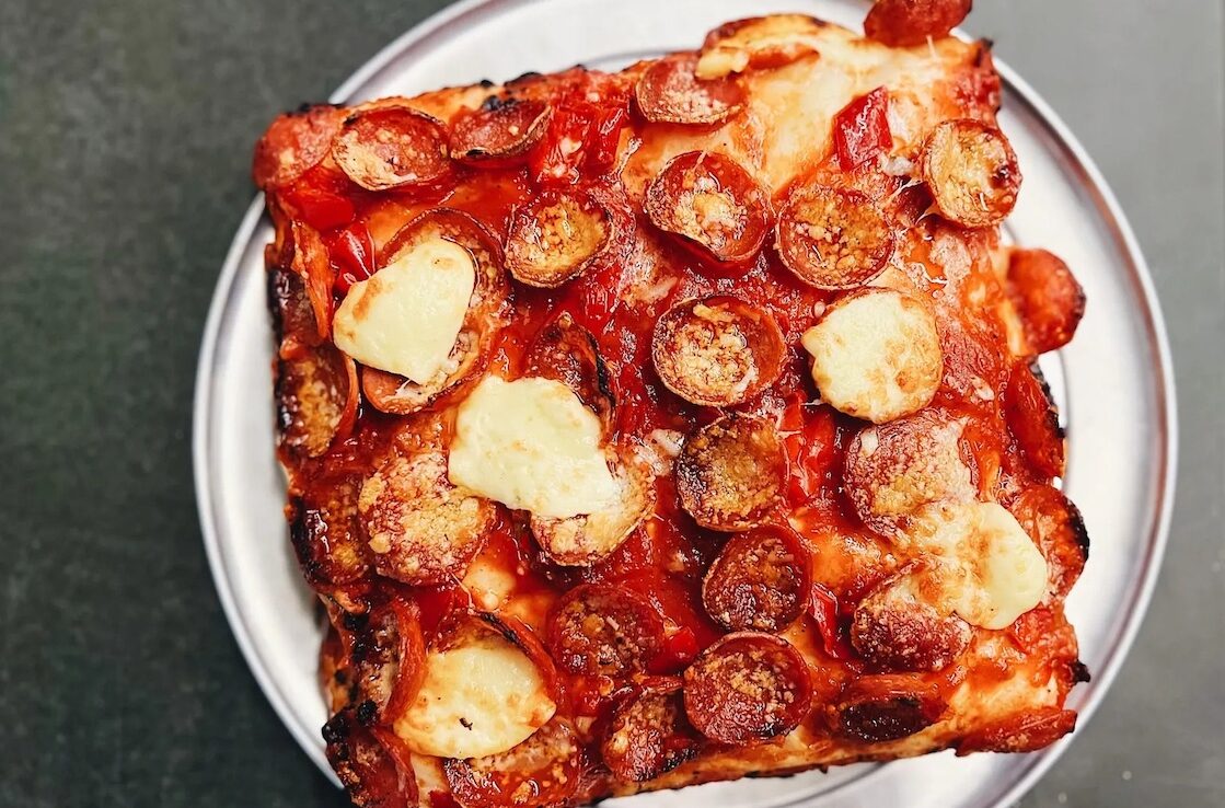 This photo shows a gluten-free pizza on a metal tray.