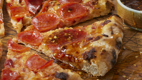 This photo shows a gorgeous pepperoni pizza drizzled with hot honey.