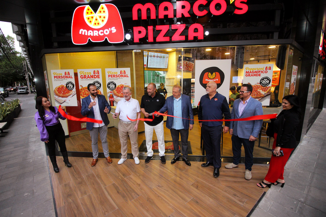 This photo shows a group of men cutting the ribbon at the grand opening of a Marco's Pizza location in Mexico City.