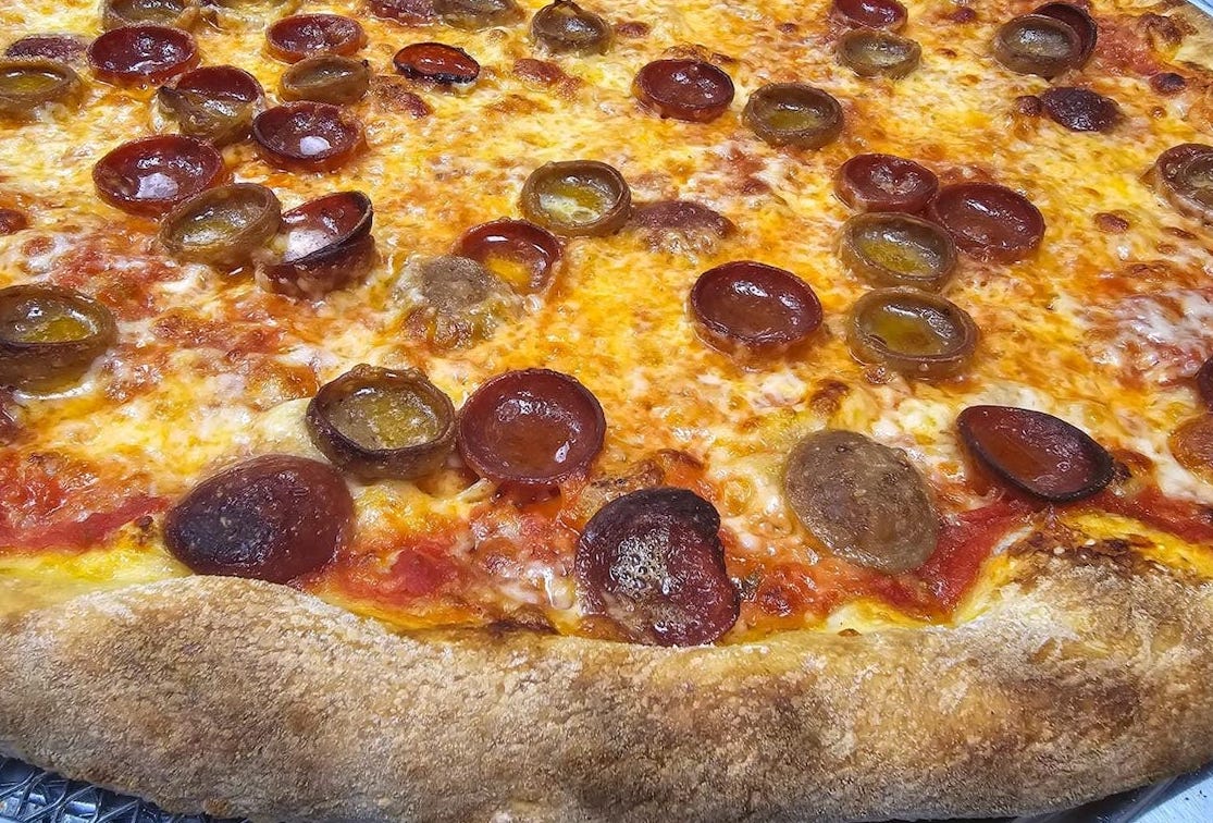 This photo shows a close-up of a pizza with cup-and-char pepperoni and a mozzarella and cheddar blend.