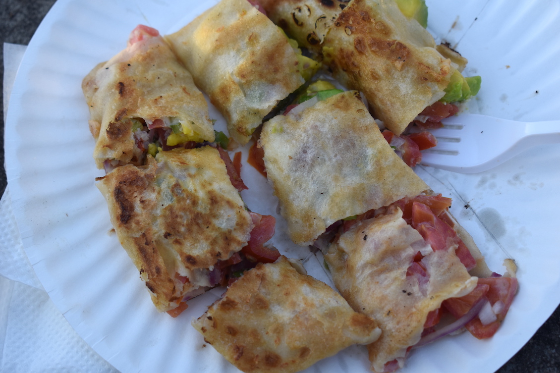 This photo shows a vegetable filled Zanzibar "pizza" cut into thick slices with golden brown dough.