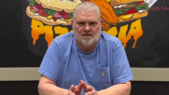This photo shows Frank Steele, with close-cropped gray hair and wearing a blue shirt, talking to the camera for a video.