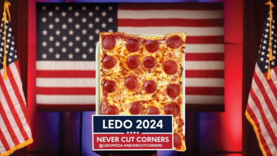 This photo shows a Ledo pepperoni pizza flanked by U.S. flags and a banner that reads, "Ledo 2024: Never Cut Corners."