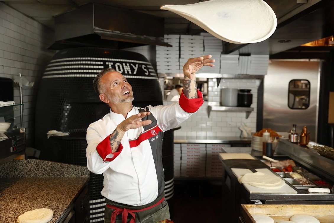 This photo shows Tony Gemignani tossing pizza dough in the kitchen of one of his restaurants.
