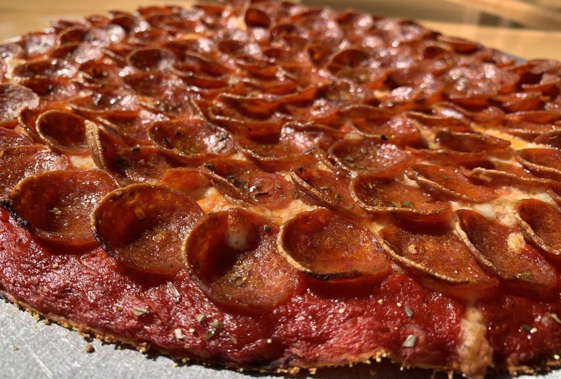 This photo shows a pizza piled with pepperoni.