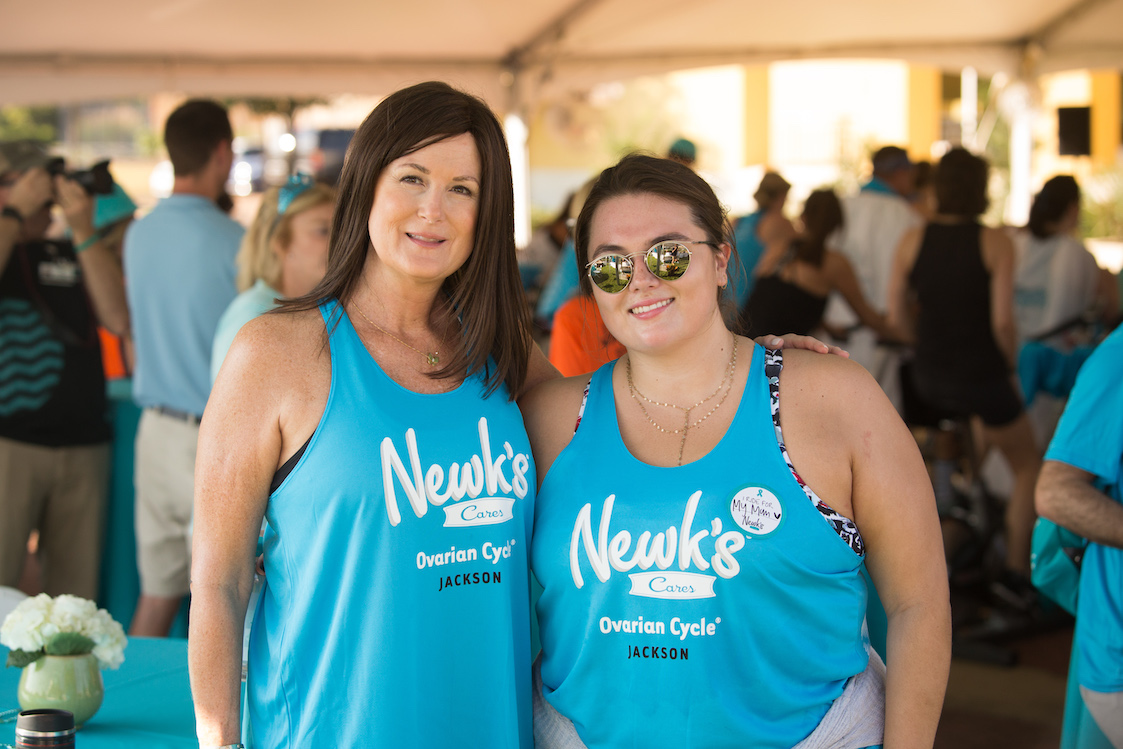 This photo shows the late Lori Newcomb and her daughter, Madison, wearing light-blue Newt's t-shirts, posing together at a spin fundraiser for ovarian cancer research.