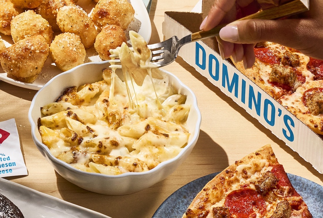 This photo shows Domino's new Mac & Cheese bowl alongside other menu items, including two pizzas.