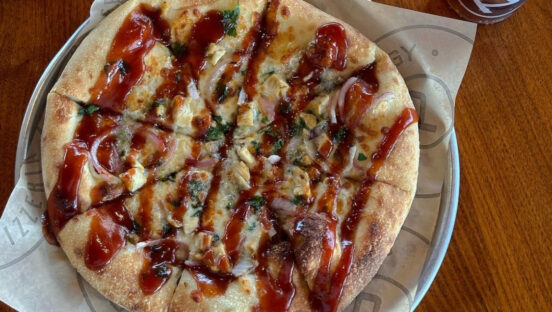This photo shows a Pieology pizza drizzled with a hot honey BBQ sauce.