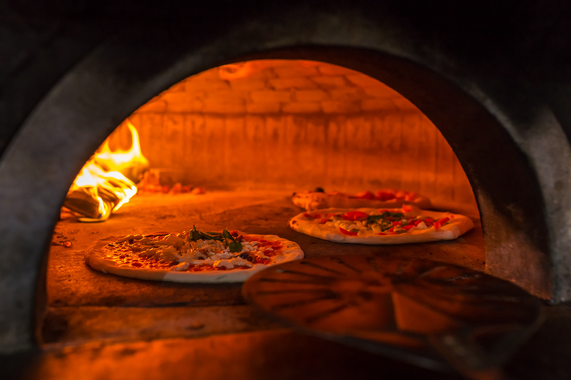 This photo shows a Neapolitan pizza margherita in a traditional wood oven in Naples restaurant, Italy