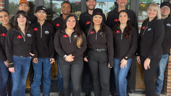 This photo shows a group of 12 employees, all wearing company-branded uniforms, at a Parry's location.
