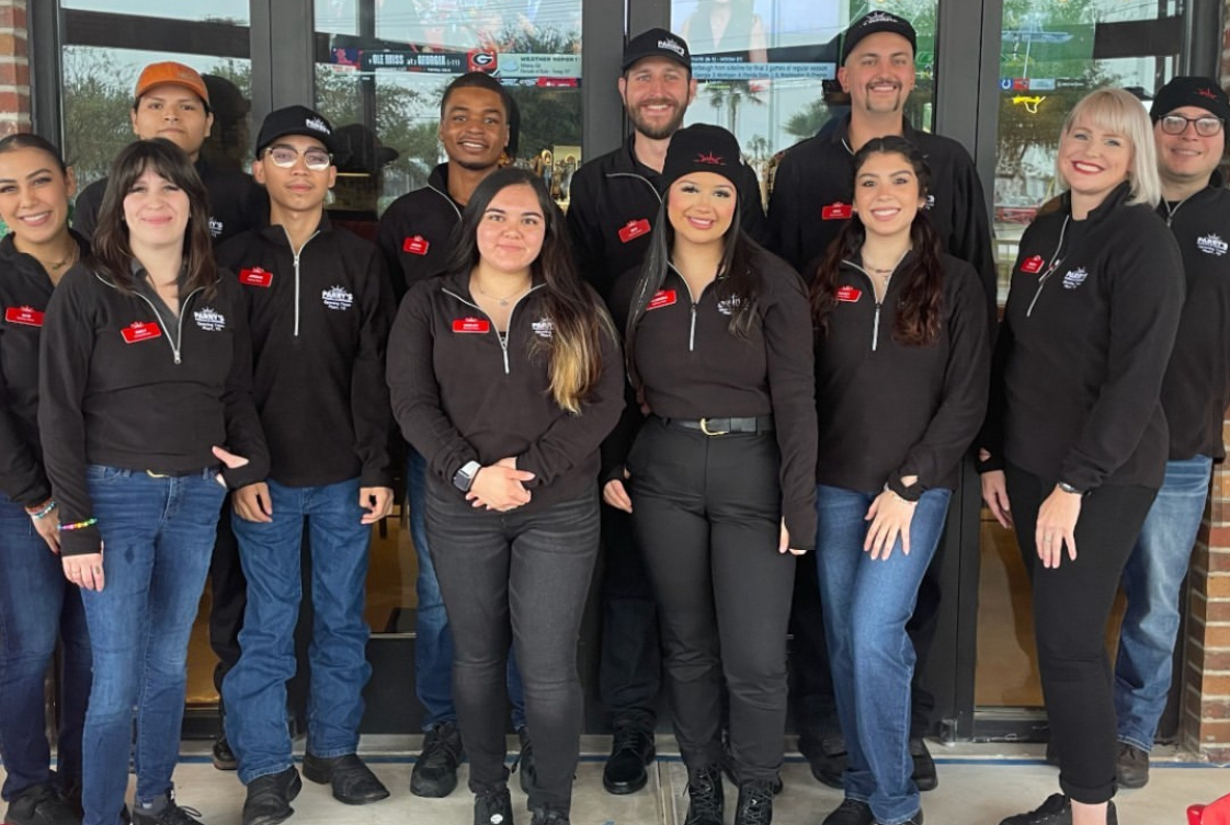 This photo shows a group of 12 employees, all wearing company-branded uniforms, at a Parry's location.