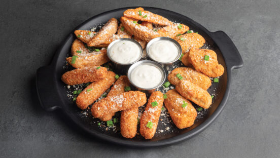 a platter of shareable appetizers with ranch cups in the middle.