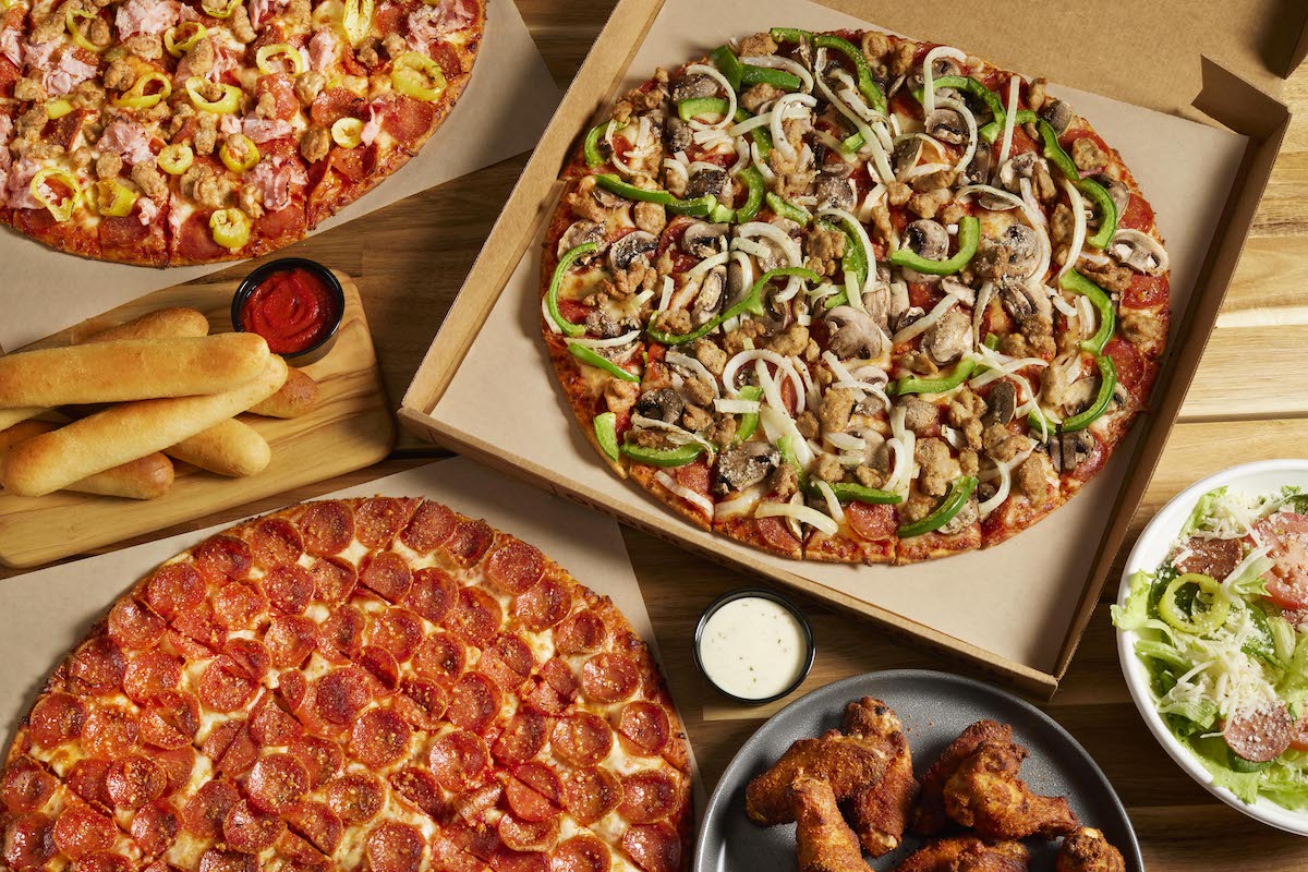 A sprawling number of menu offerings from Donatos Pizza: Pepperoni Pizza, Works Pizza, Traditional Wings Dry Rub, and a side salad.