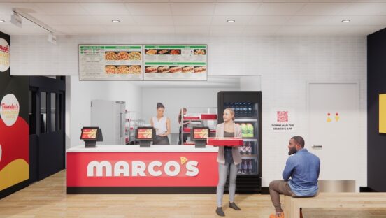 This photo shows a woman holding a pizza carryout box in front of the counter at a Marco's Pizza location.