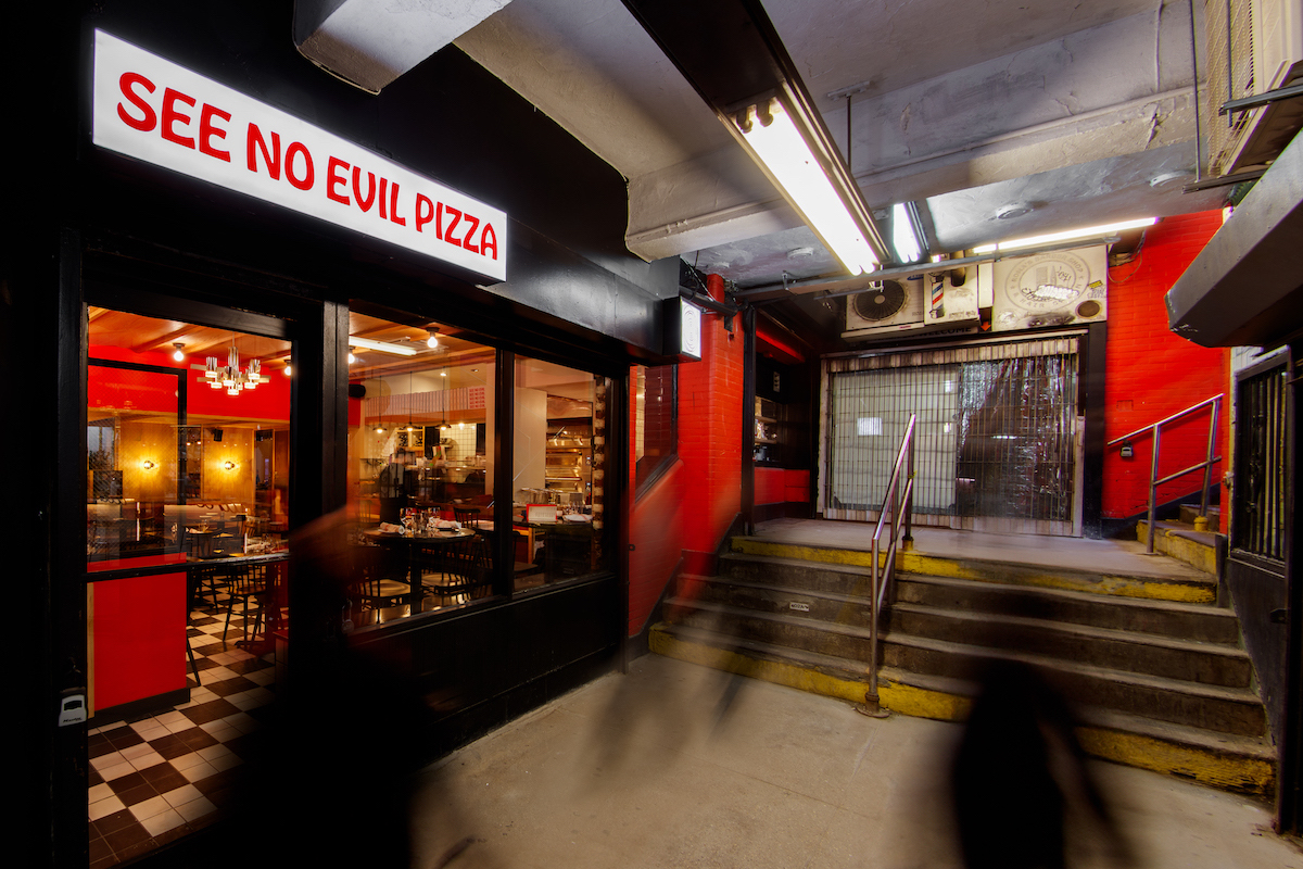 A pizza shop, at left, sits at the bottom of Subway stairs in New York City.