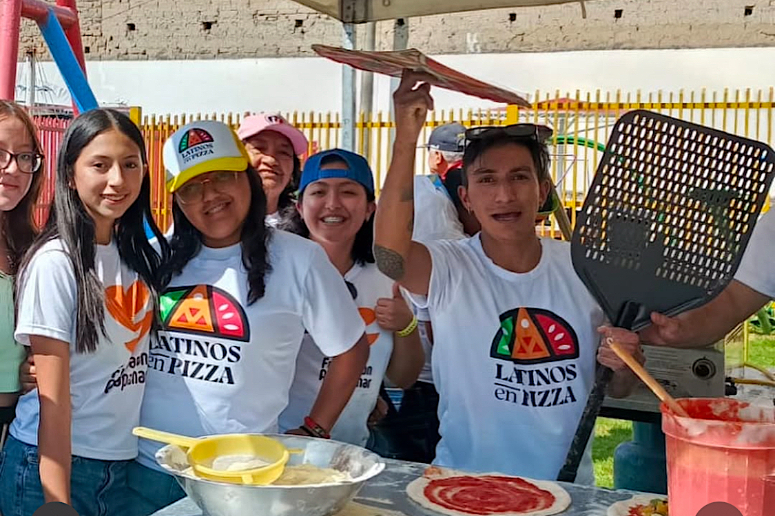 This photo shows a group of young Ecuadorians wearing Latinos en Pizza t-shirts at the festival. One boy is spinning pizza dough.