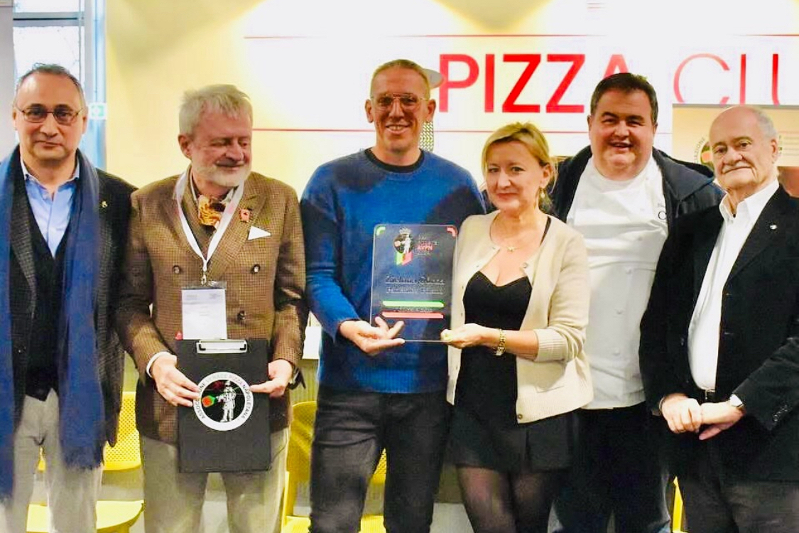 This photo shows the owners of Zielona Gorka, a husband-and-wife team, holding their award from AVPN, flanked by a group of other unidentified men.