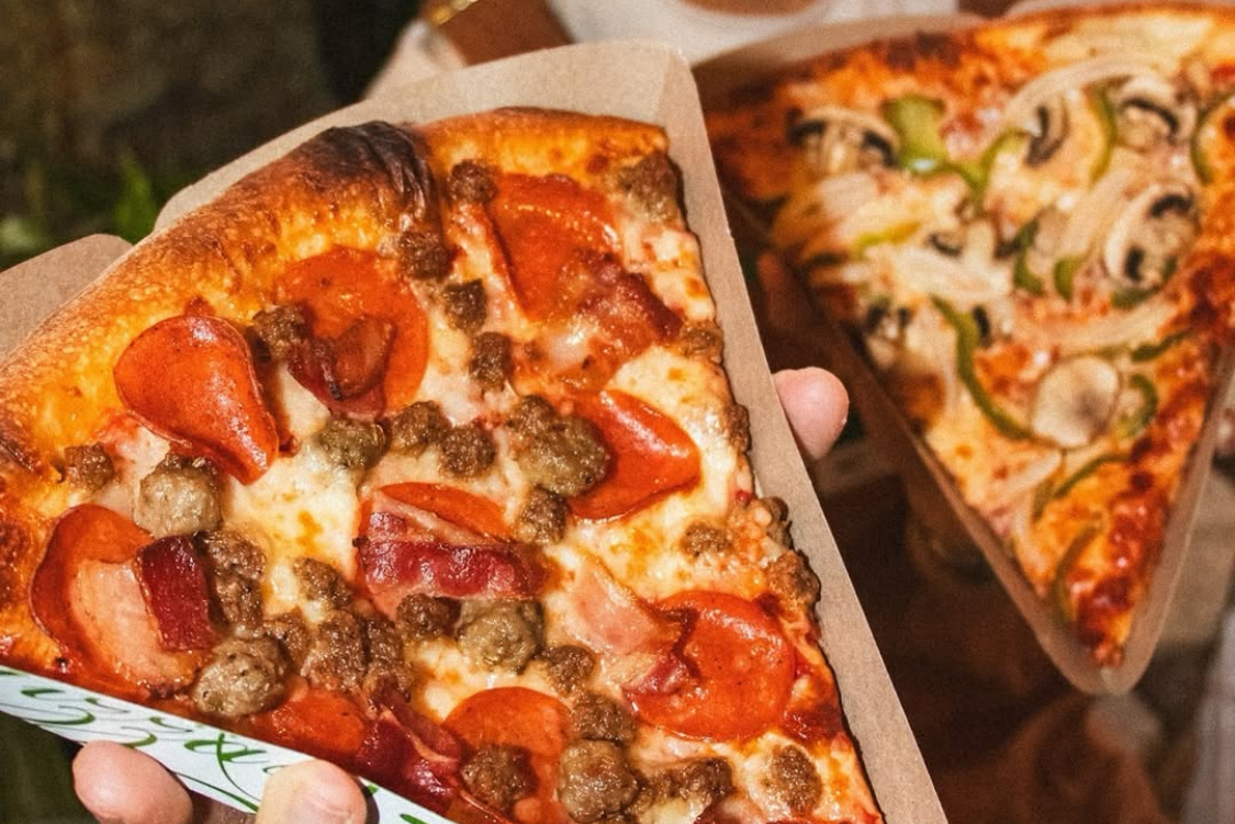 This photo shows a close-up of two slices of the specialty pizzas from Pizza Nova.