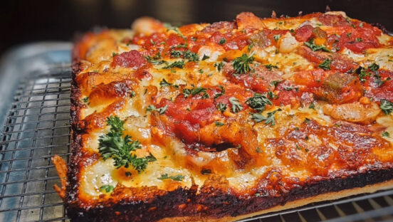 This photo shows a jambalaya pizza topped with shrimp, chicken and sausage.