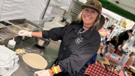 This photo shows Mel Fucilla working in her pizza-making tent at an event.