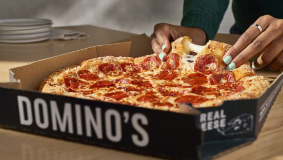 This photo shows a cheese pull from a slice of Domino's Parmesan Stuffed Crust pizza.