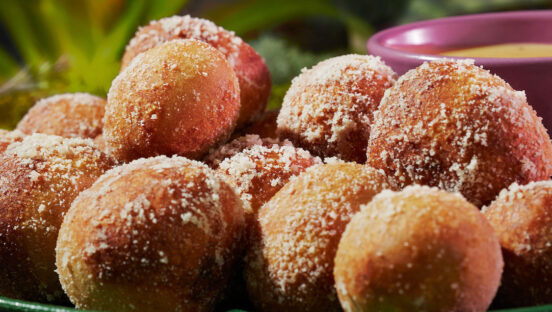 This photo shows a pile of Mellow Mushroom's pretzel bites on a green plate with a spring-like floral background.