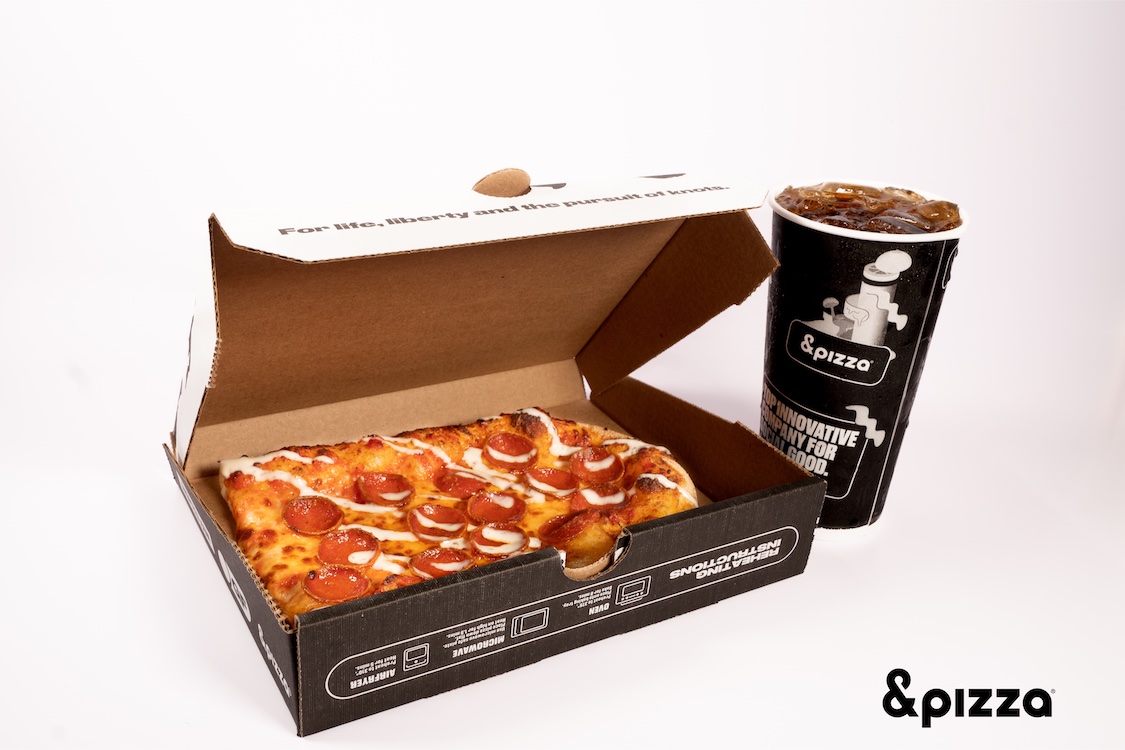 This photo shows a pepperoni pie with some kind of white drizzle in a pizza box along with a beverage cup.