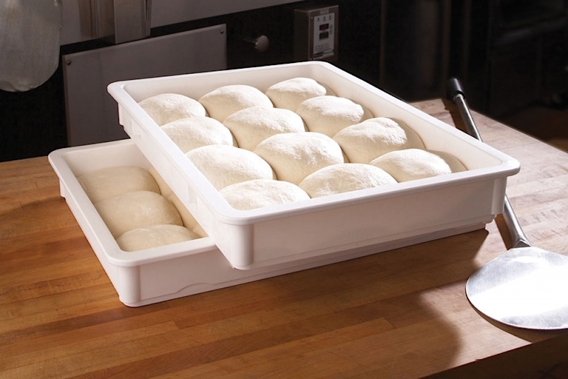 This photo shows a pair of cross-stacked dough trays, with the top tray containing nine dough balls.