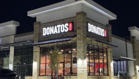 This photo shows the exterior of a Donatos restaurant at night.