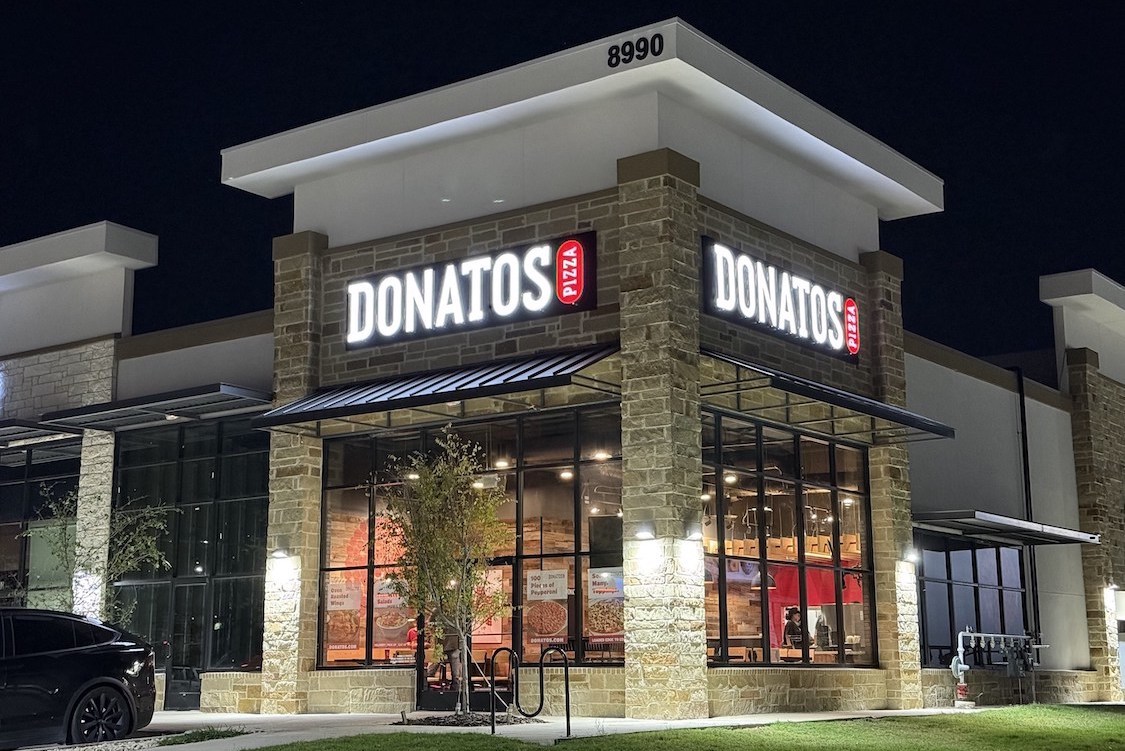 This photo shows the exterior of a Donatos restaurant at night.