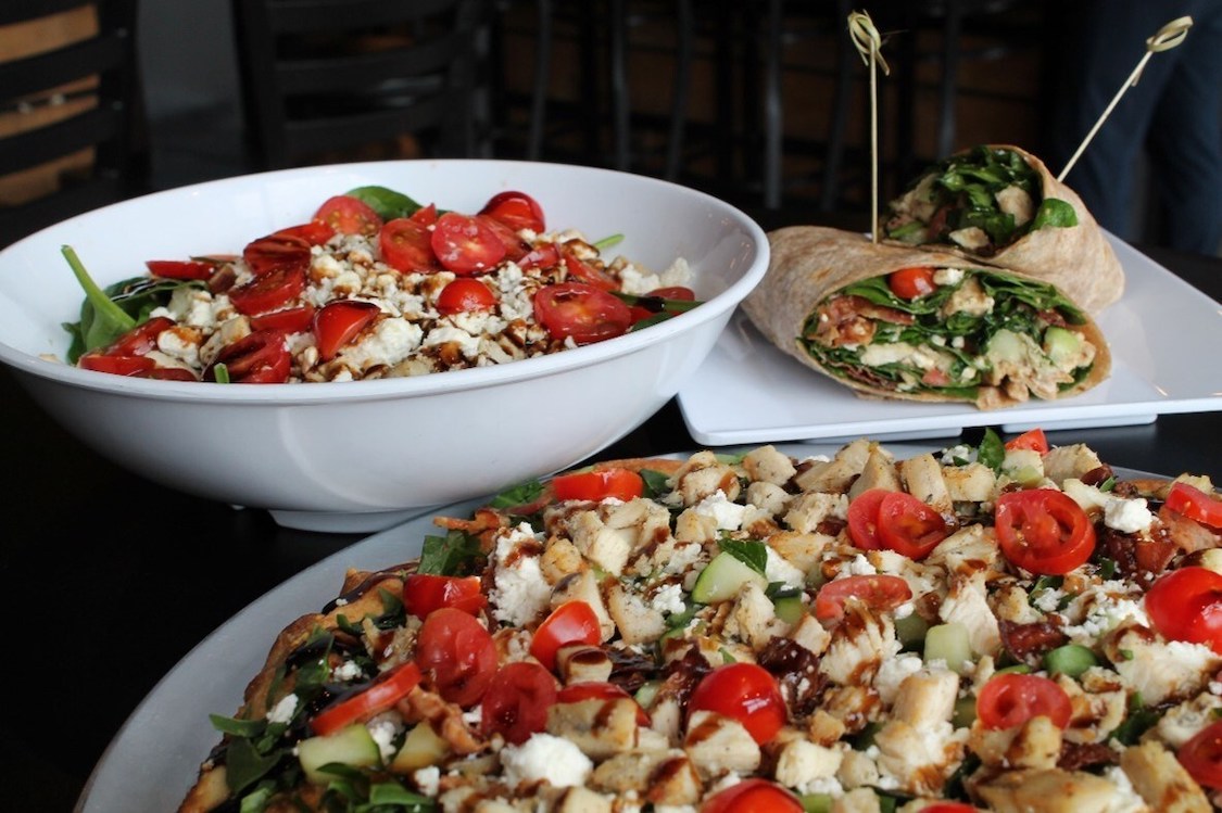 This photo shows a bowl of salad, a salad pizza and a salad wrap.