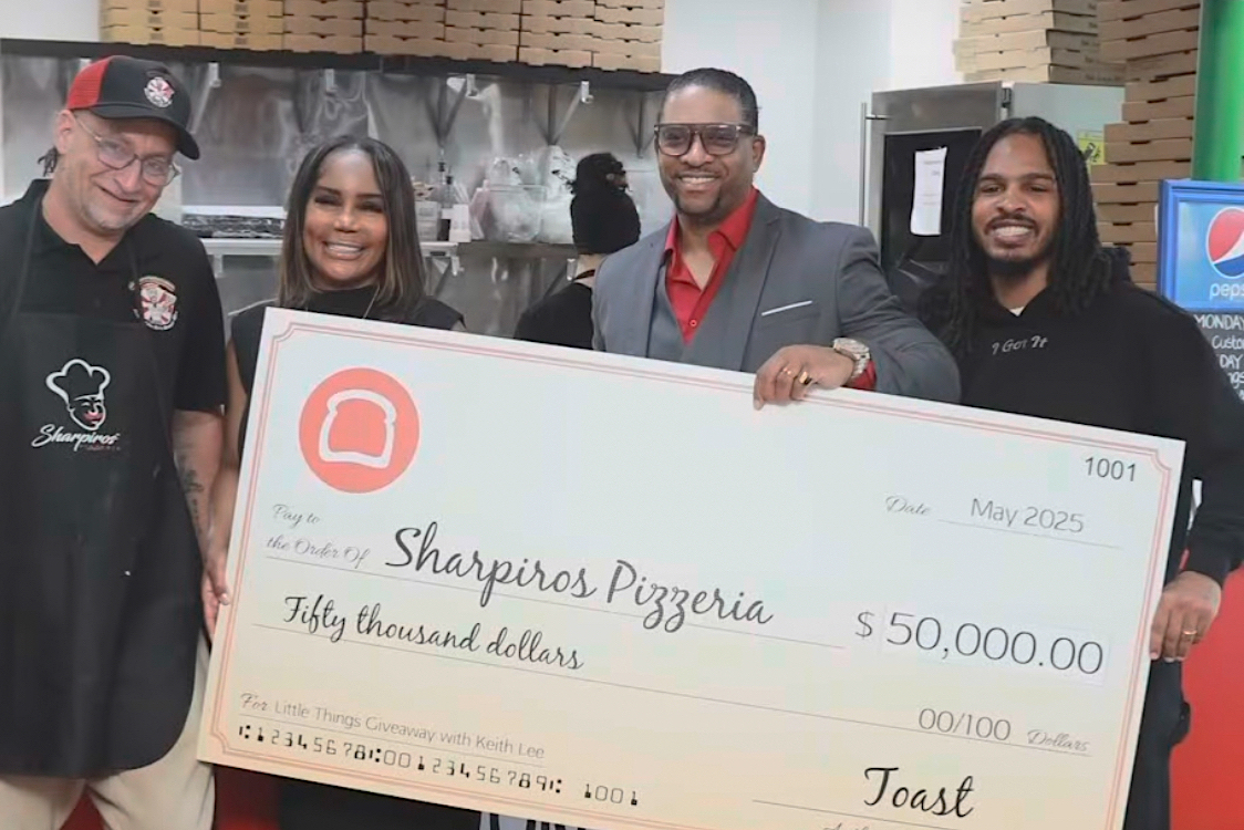 This photo shows Sharpiro's Pizzeria owners and head pizzaiolo receiving a gigantic check for $50,000 from Keith Lee.
