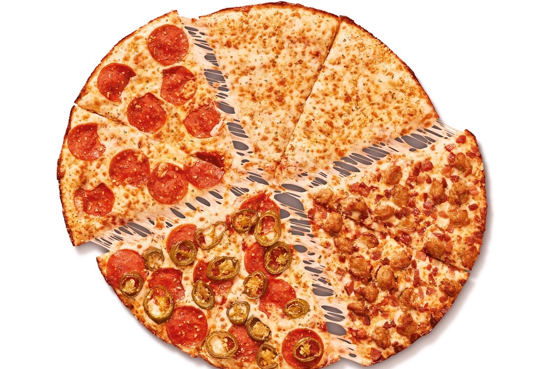 This photo shows a whole pie, cut into slices, of the Fantastic 4 in 1 pizza described in the article.