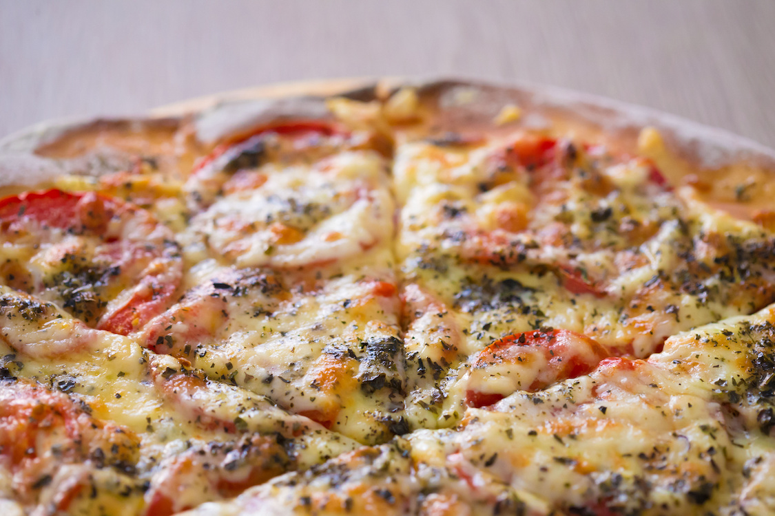 This photo shows a tasty-looking Margherita pizza with mozzarella and tomatoes.