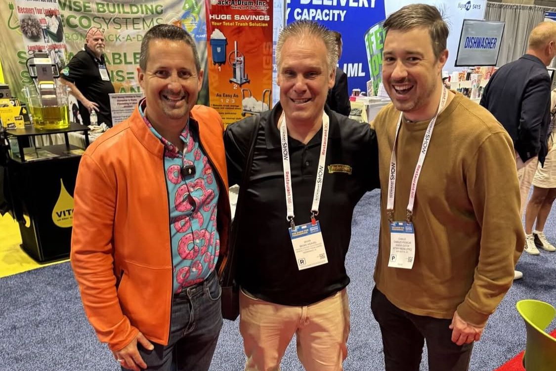 This photo shows Matt Plapp with Brian Weevel and PMQ's Charlie Pogacar, all smiling with their arms around each other, on the floor of the National Restaurant Association Show.
