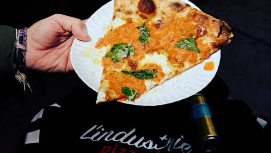 This photo shows a slice of pizza with mozzarella, basil and a vodka sauce.