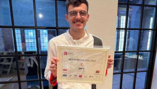 This photo shows Joe Powers holding up his 50 Top Pizza certificate at last year's worldwide ceremony.