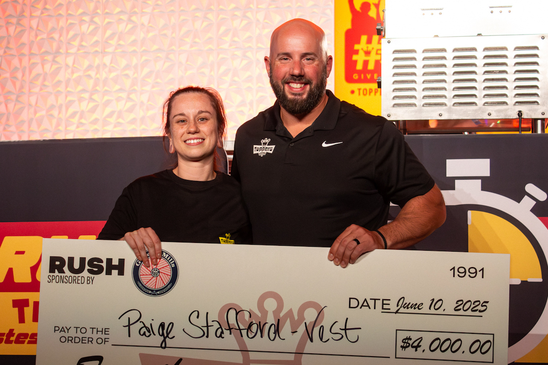 This photo shows the winner of the Rush Competition holding an oversized check for $4,000, presented by CEO Adam Oldenburg.