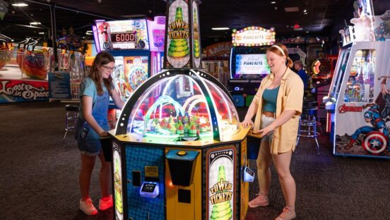 This video shows two teenage girls playing a colorful redemption game at an Incredible Pizza location.